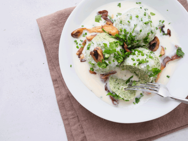 Spinat-Kräuterknödel mit cremiger Käsesahnesoße